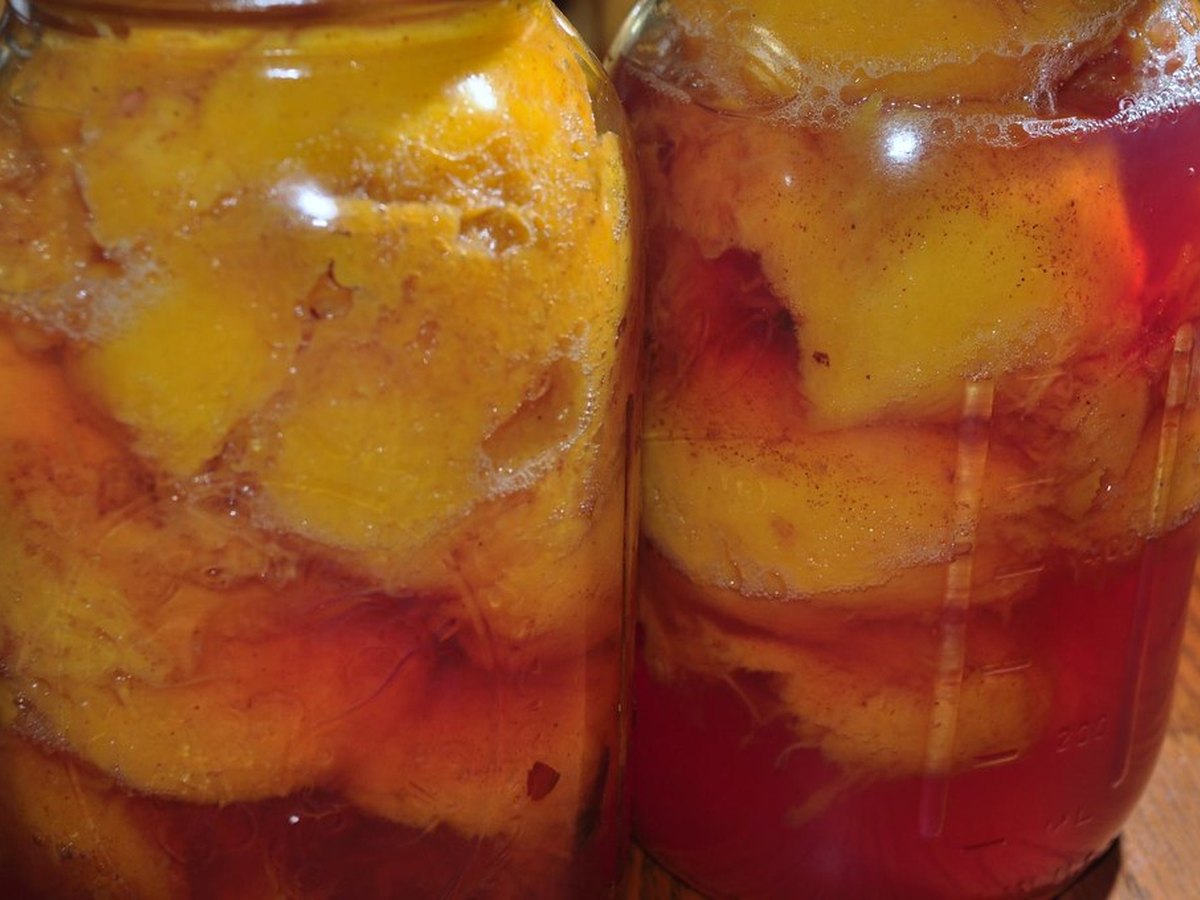 Eingekochte Pfirsichhälften in Gläsern mit Sirup