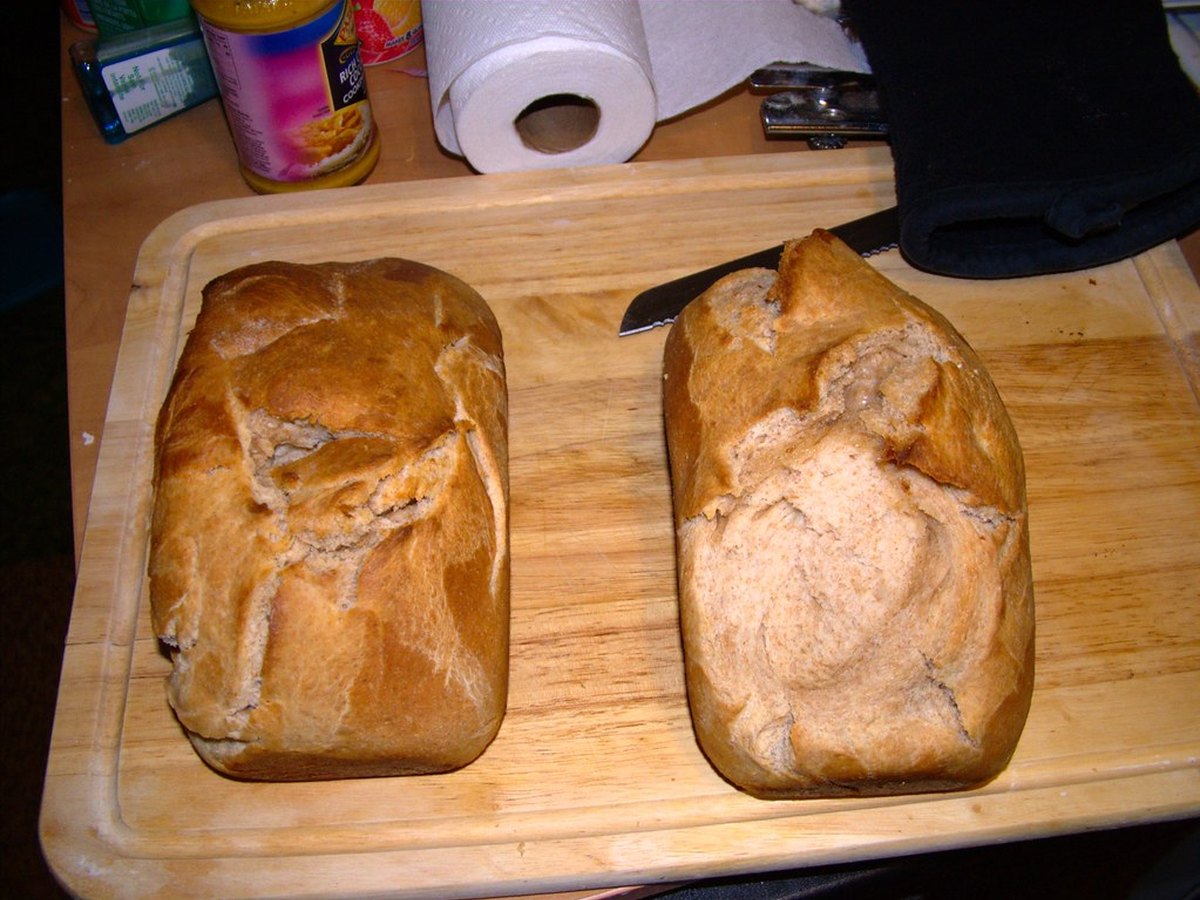 Zwei frisch gebackene Brote mit goldener Kruste auf einem Brett