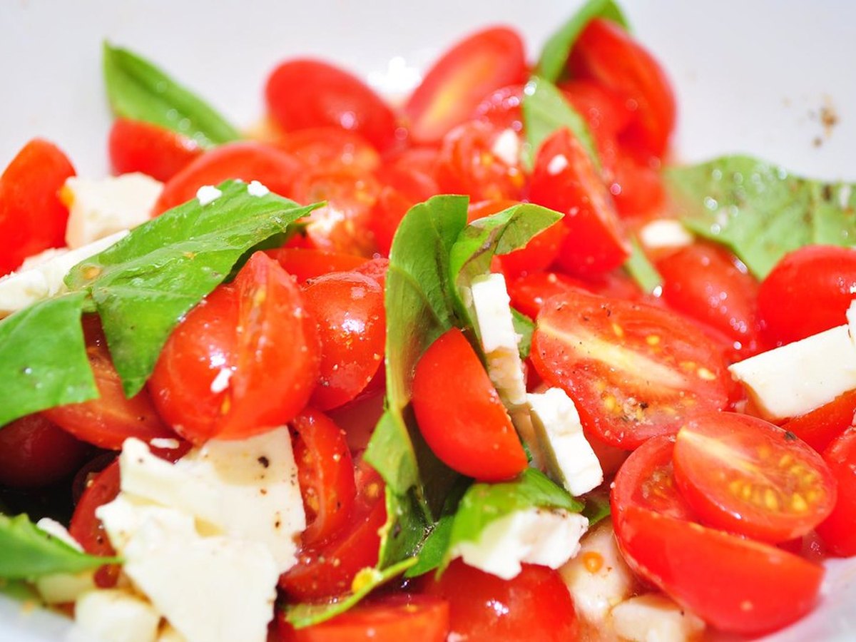 Frische Tomaten mit Basilikum auf Holz