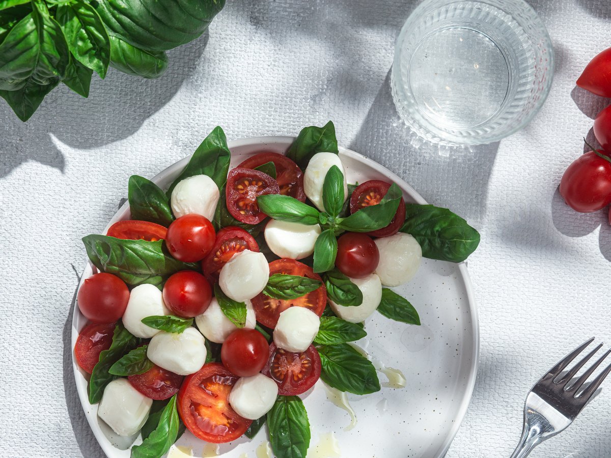 Tomaten, Mozzarella und Basilikum nebeneinander angerichtet