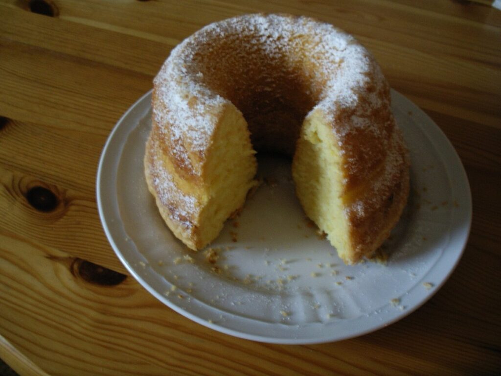 Gugelhupf mit Puderzucker bestäubt auf einem Kuchenteller