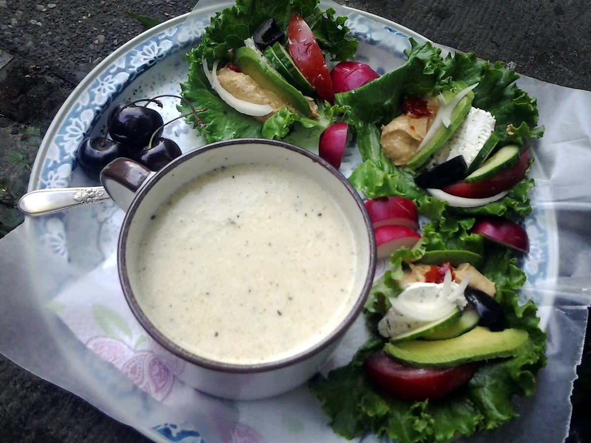Suppe mit Kräutern und Olivenöl garniert