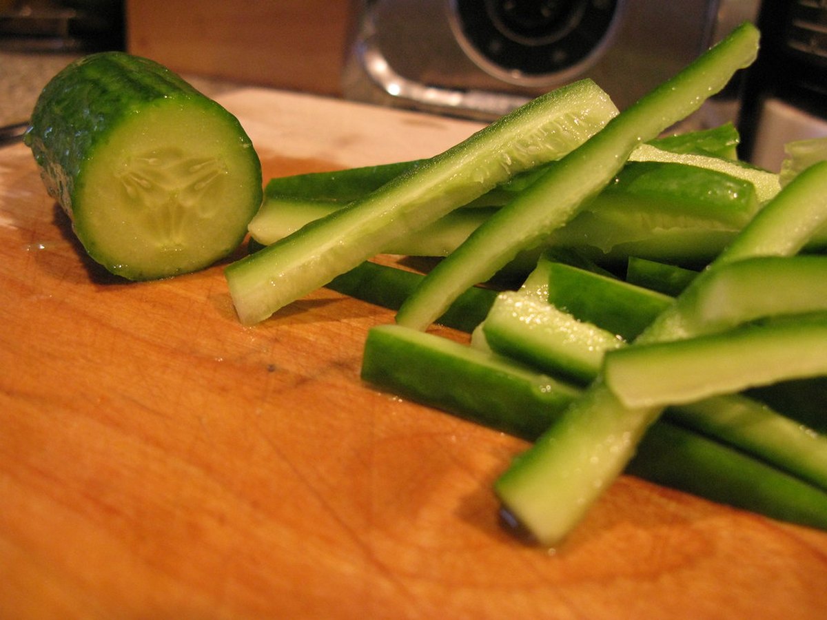 Aufgeschnittene Salatgurken auf einem Holzbrett