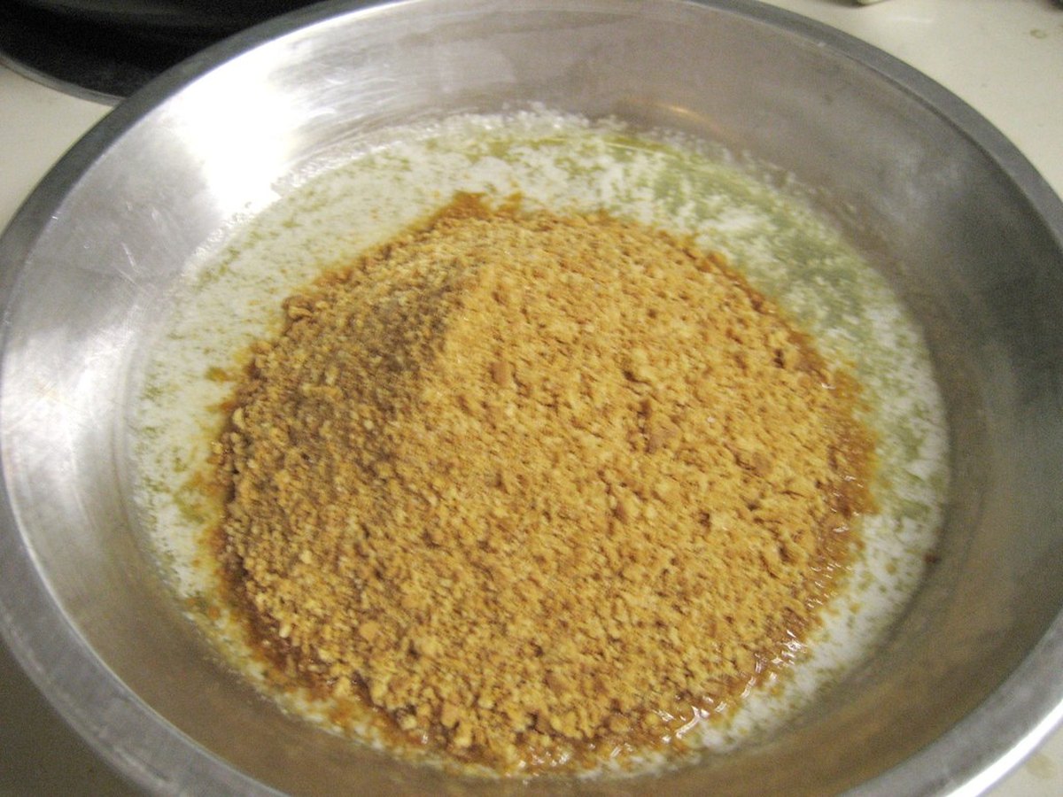 Zerbröselte Butterkekse mit Butter vermischt in einer Schüssel