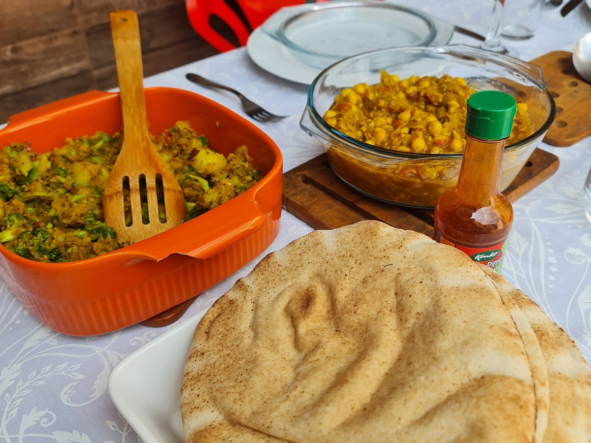 Zwei Schalen Curry mit Fladenbrot auf einem gedeckten Tisch