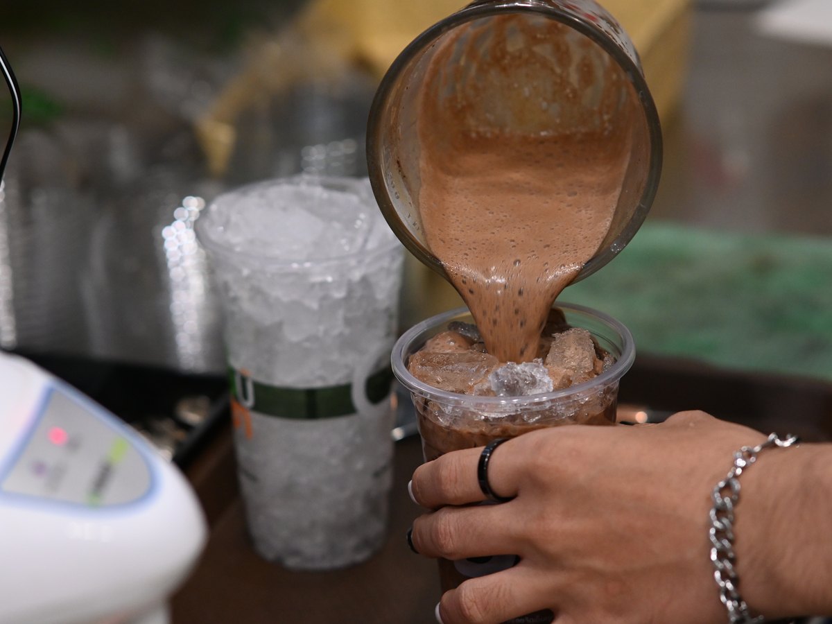 Milchshake wird aus dem Mixer gegossen
