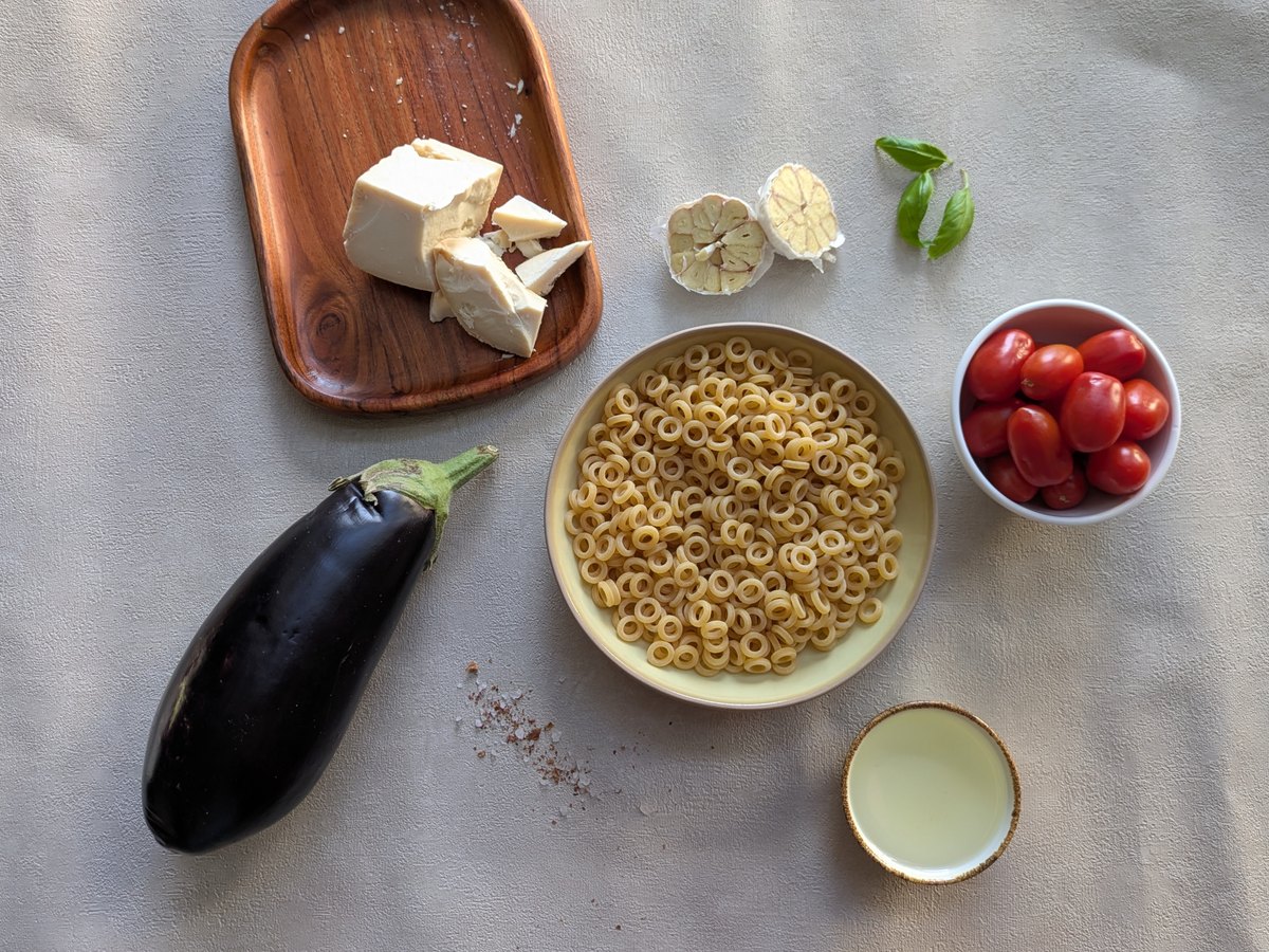 Nudeln, Kirschtomaten, Knoblauch und Basilikum auf dem Tisch