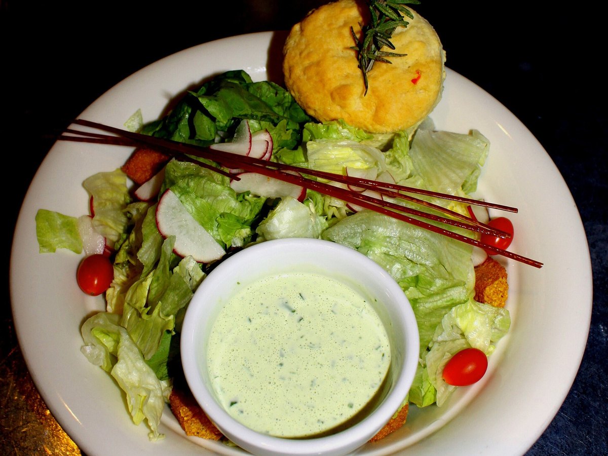 Grüner Blattsalat mit einem Schälchen Dressing