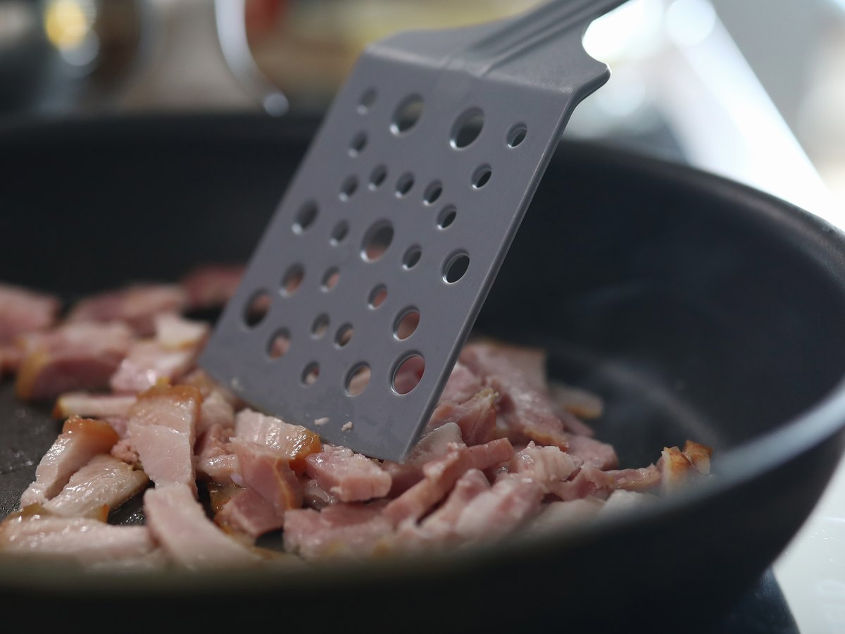 Kleine Speckwürfel braten in einer Pfanne