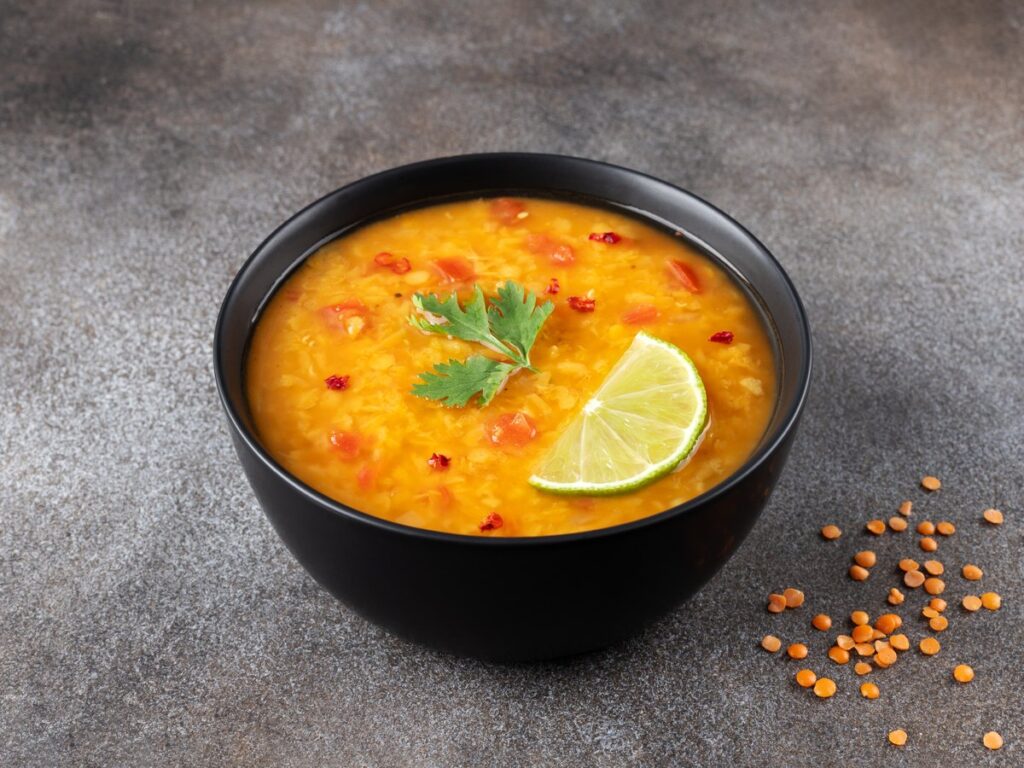 Schale rote Linsensuppe mit Gewürzen und frischen Kräutern