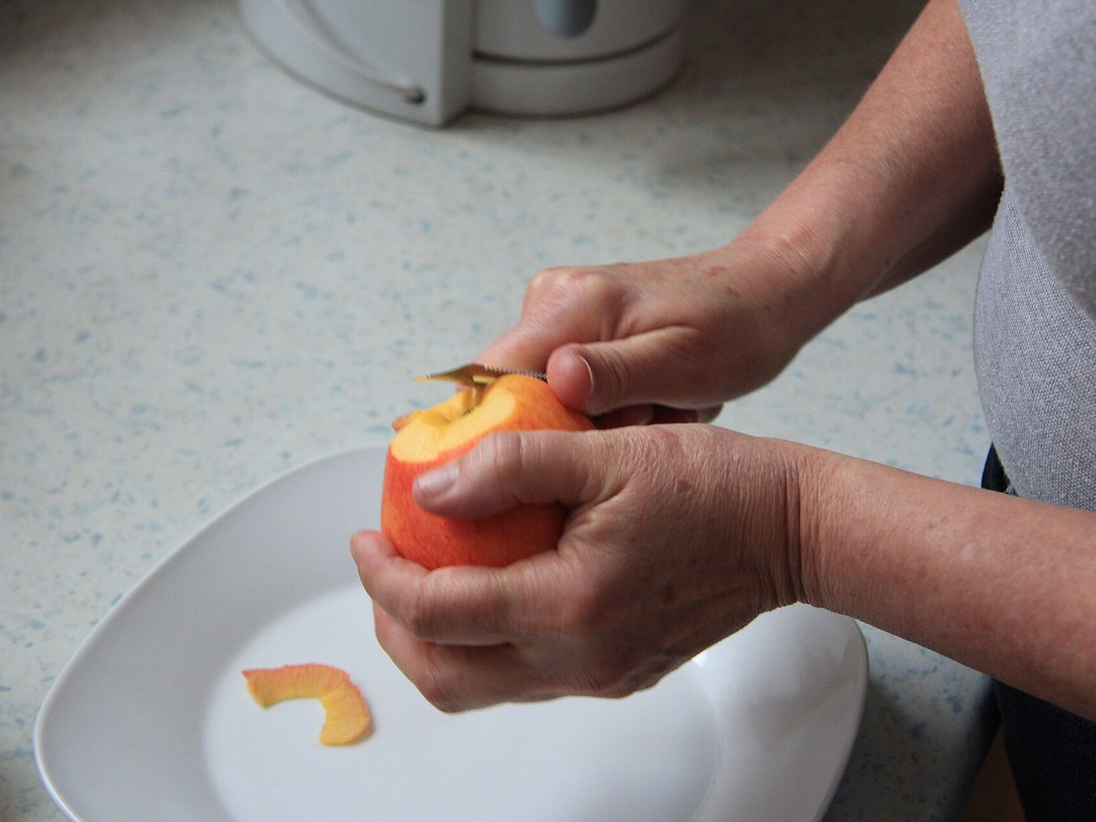 Apfel wird mit einem Messer geschält