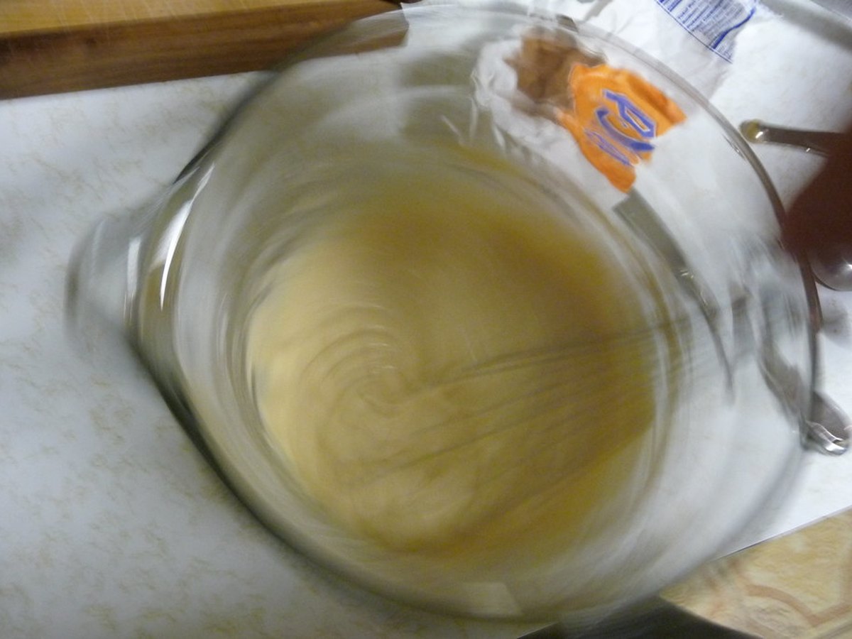 Kuchenteig wird in einer Schüssel mit dem Schneebesen verrührt