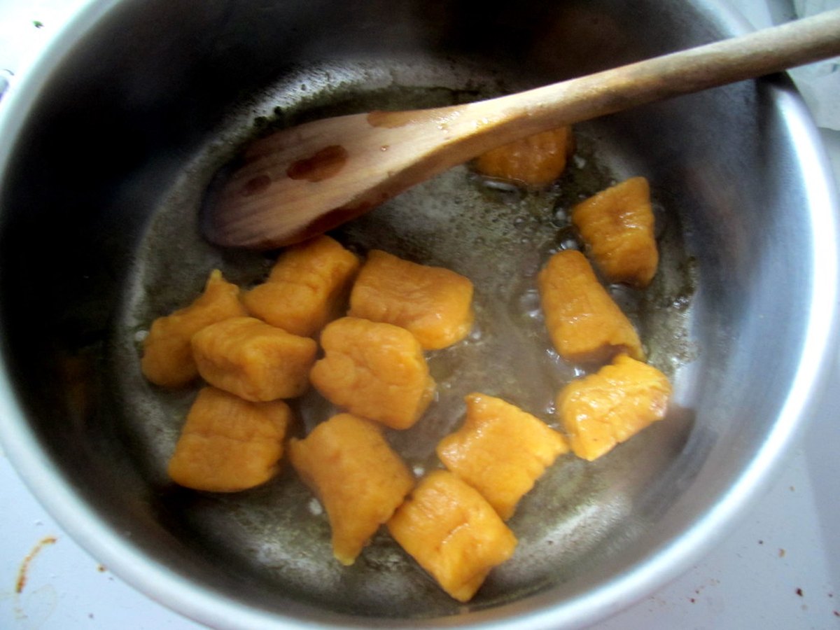 Gnocchi braten in einer Pfanne, daneben ein Holzlöffel
