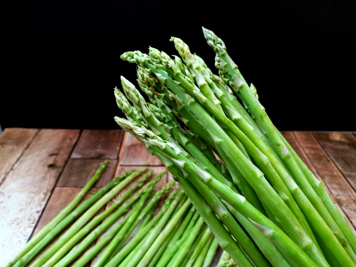 Frischer grüner Spargel auf einem Holztisch