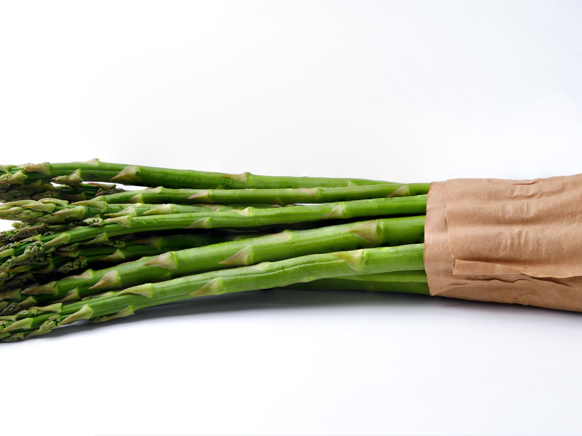 Grüner Spargel in Papier eingewickelt