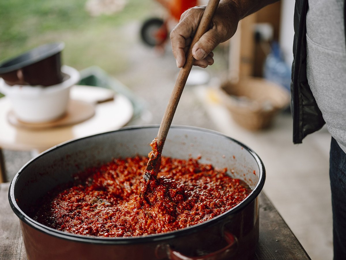 Rote Sauce wird in einem großen Topf gerührt