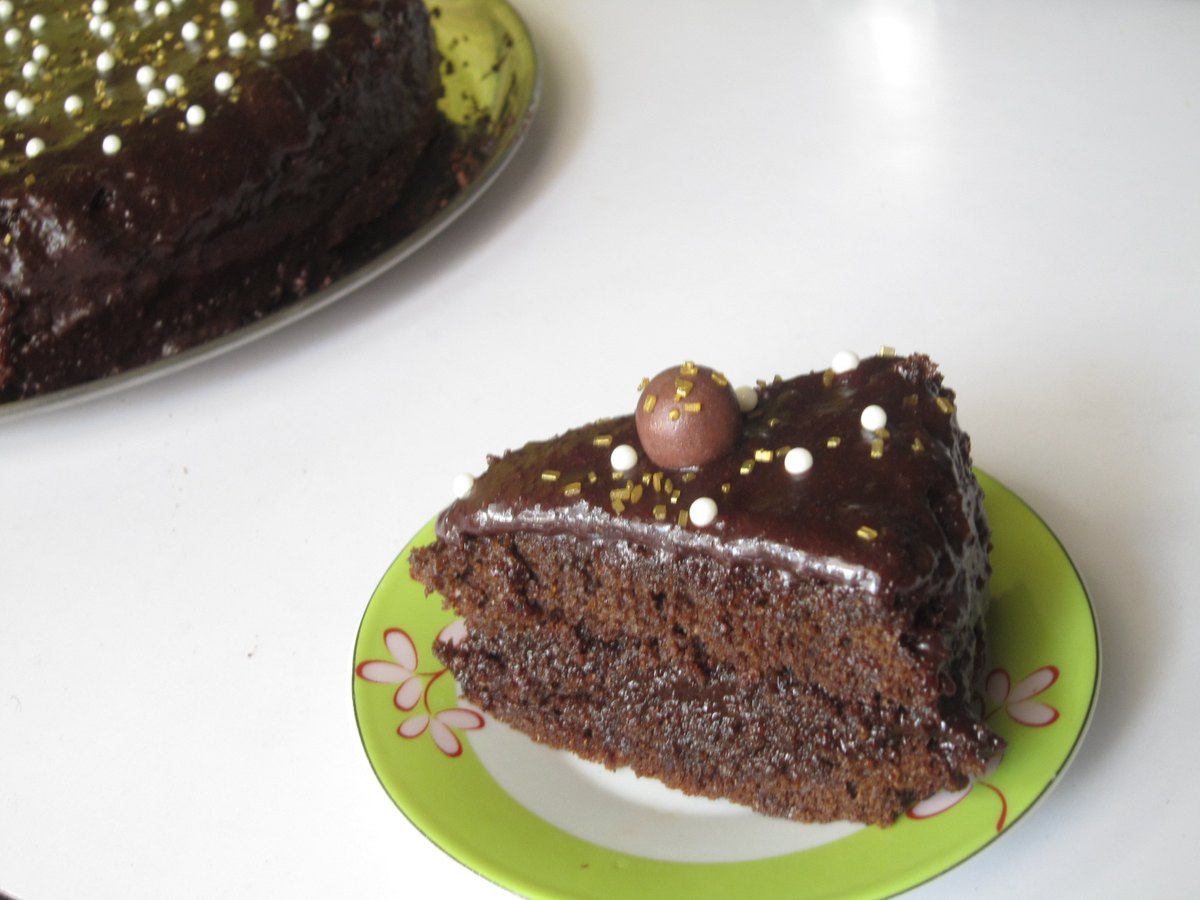 Kuchen wird mit dunkler Schokoladenglasur überzogen