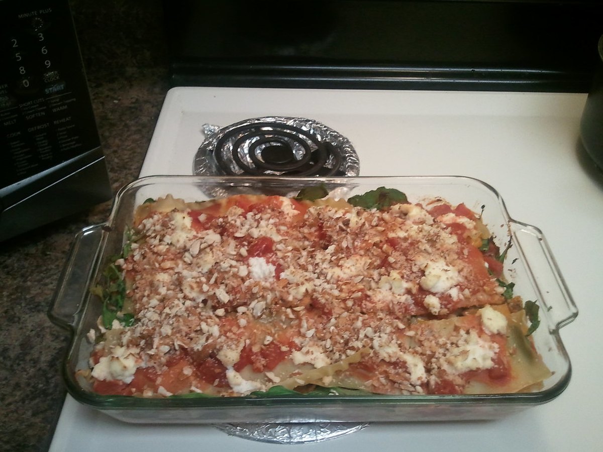 Lasagneplatten werden auf Sauce geschichtet