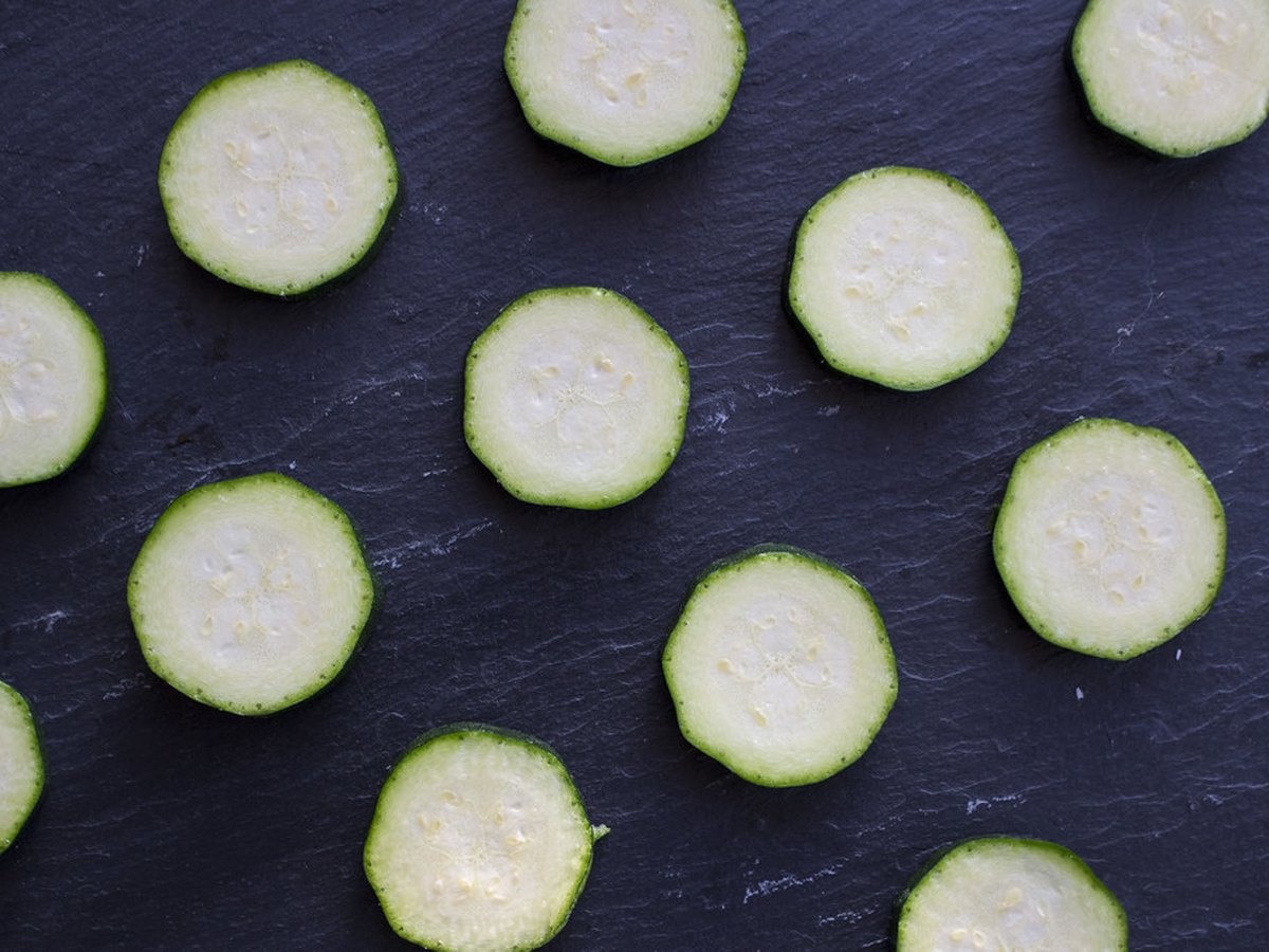 Gesalzene Zucchinischeiben im Sieb