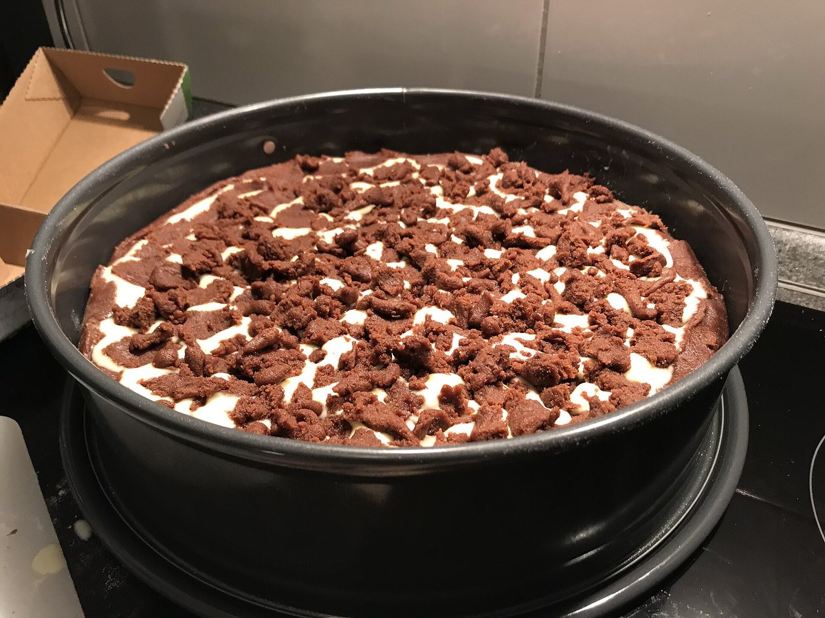 Gezupfter Teig auf der Käsekuchen-Füllung vor dem Backen